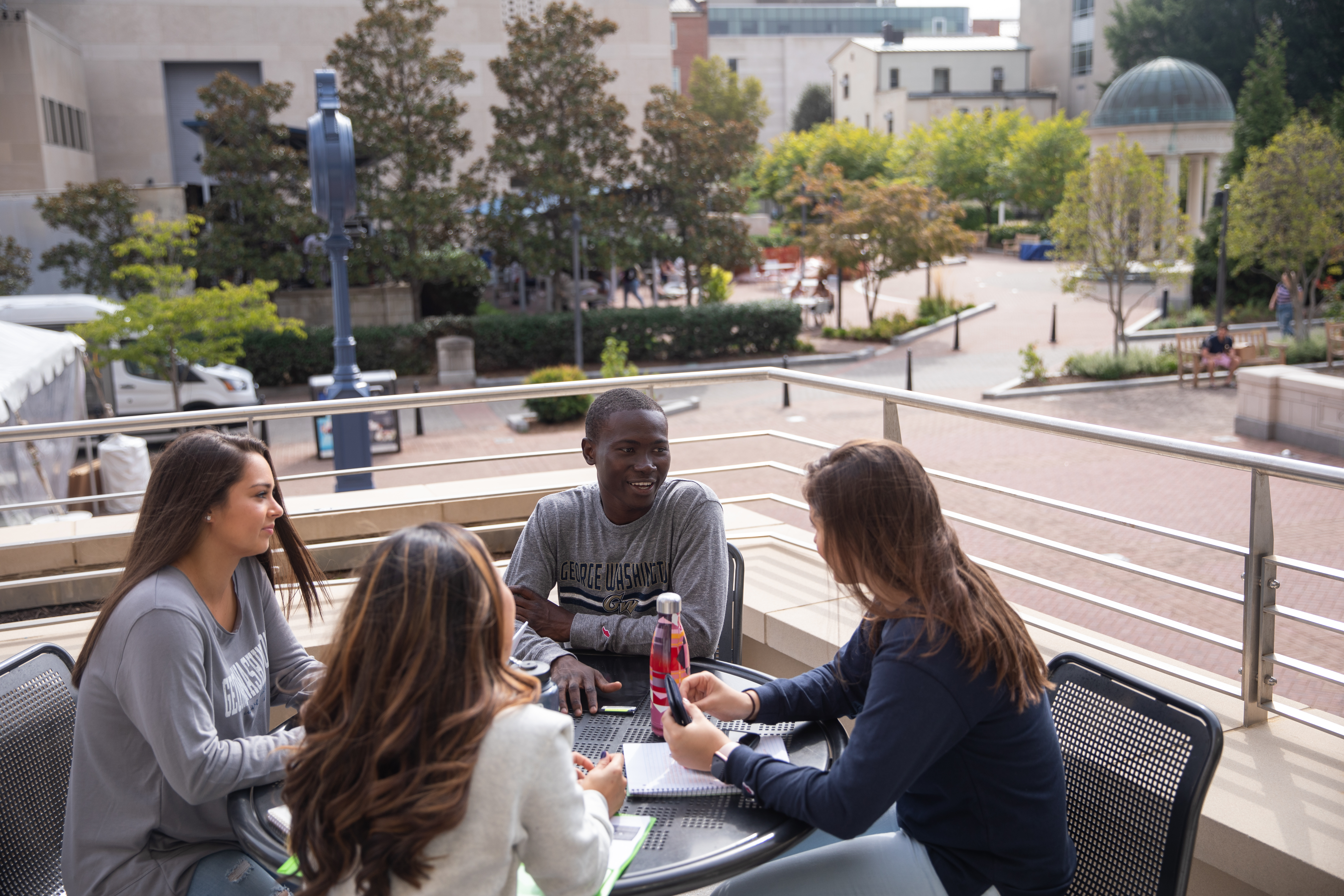 Photo of four people talking at a table